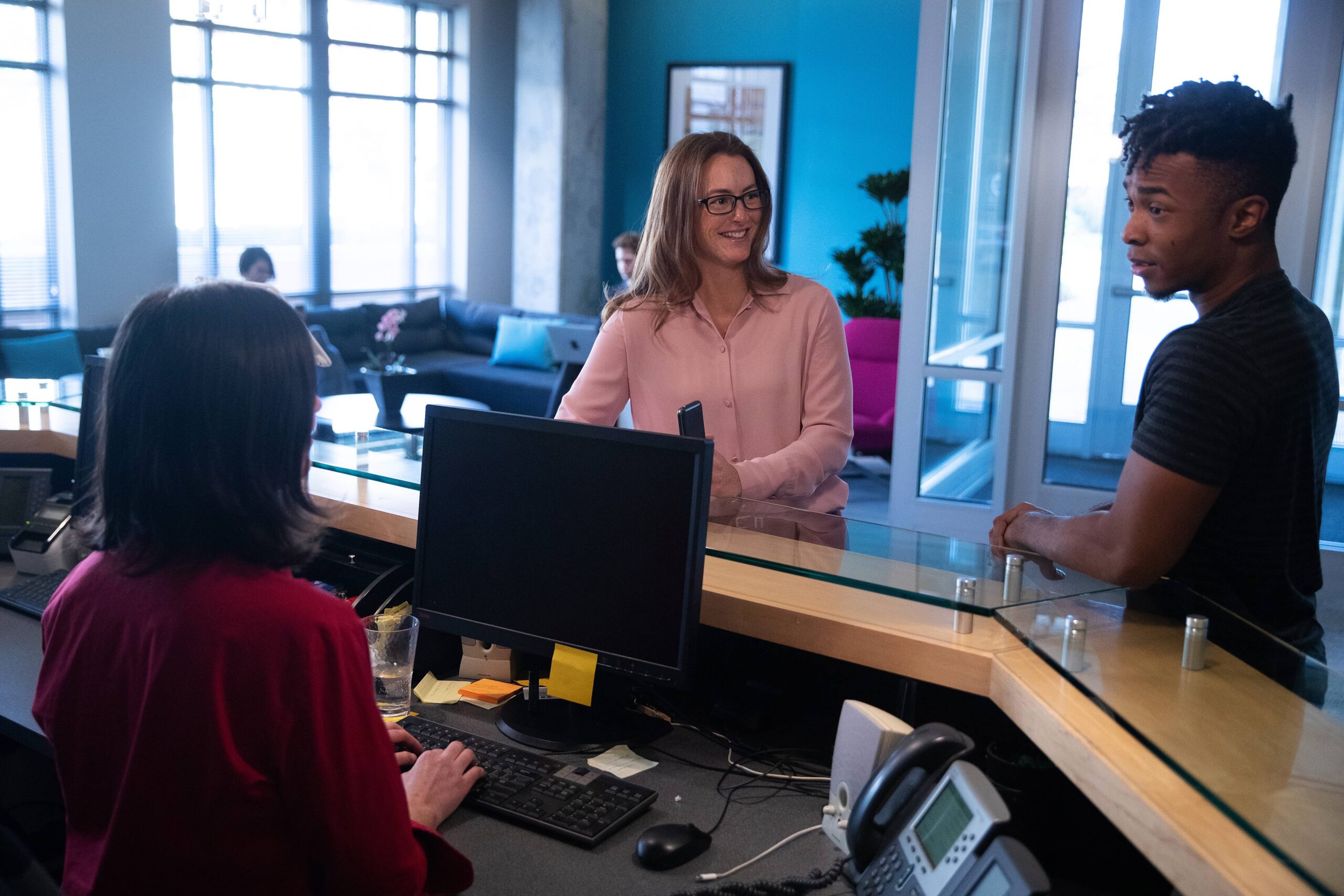 people conversing at the front office desk