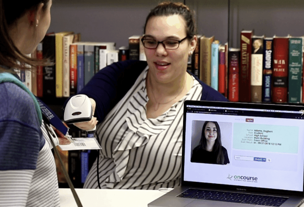 Woman scanning in a student into the library using her Student ID card