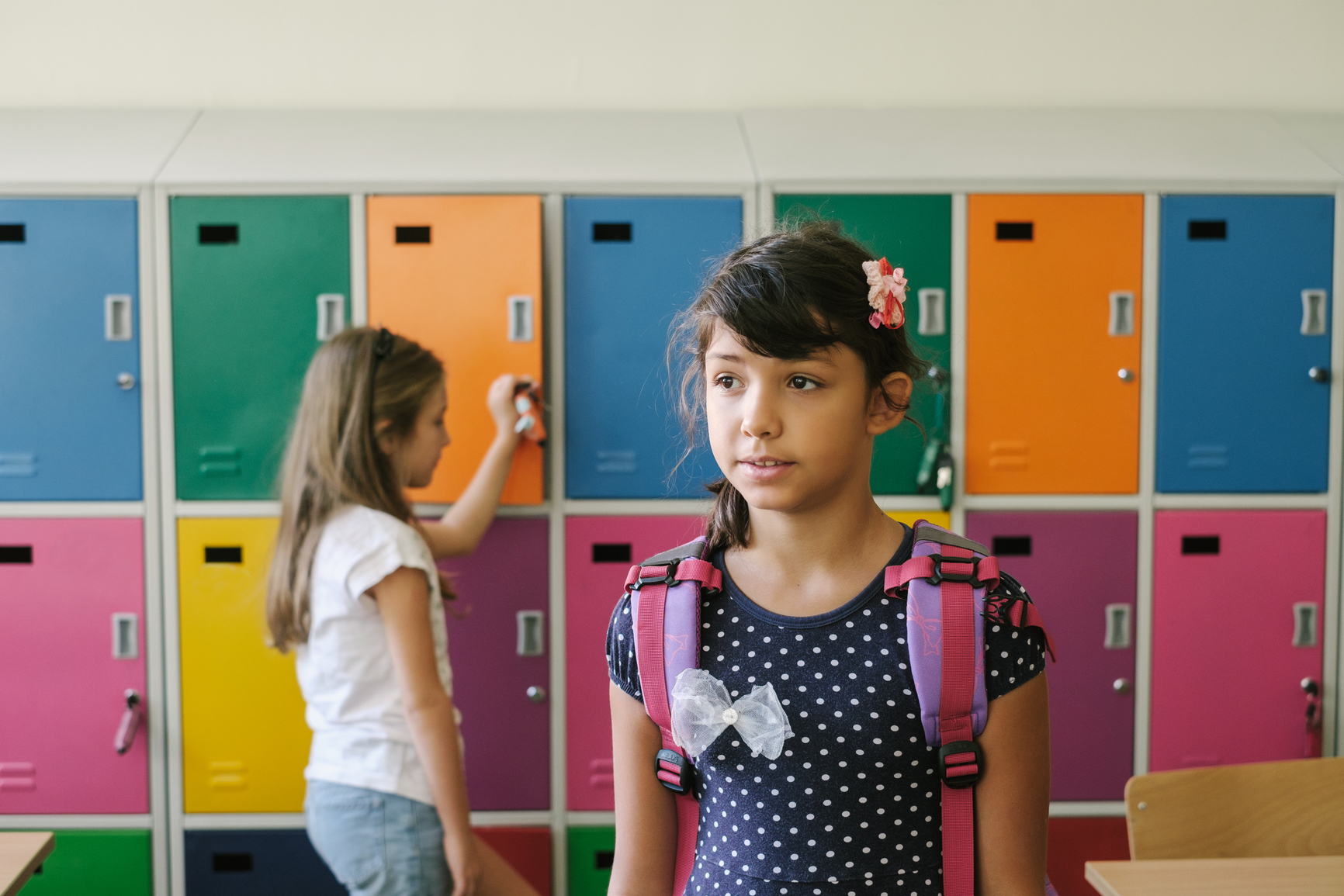 Student standing in front of color-coded lockers