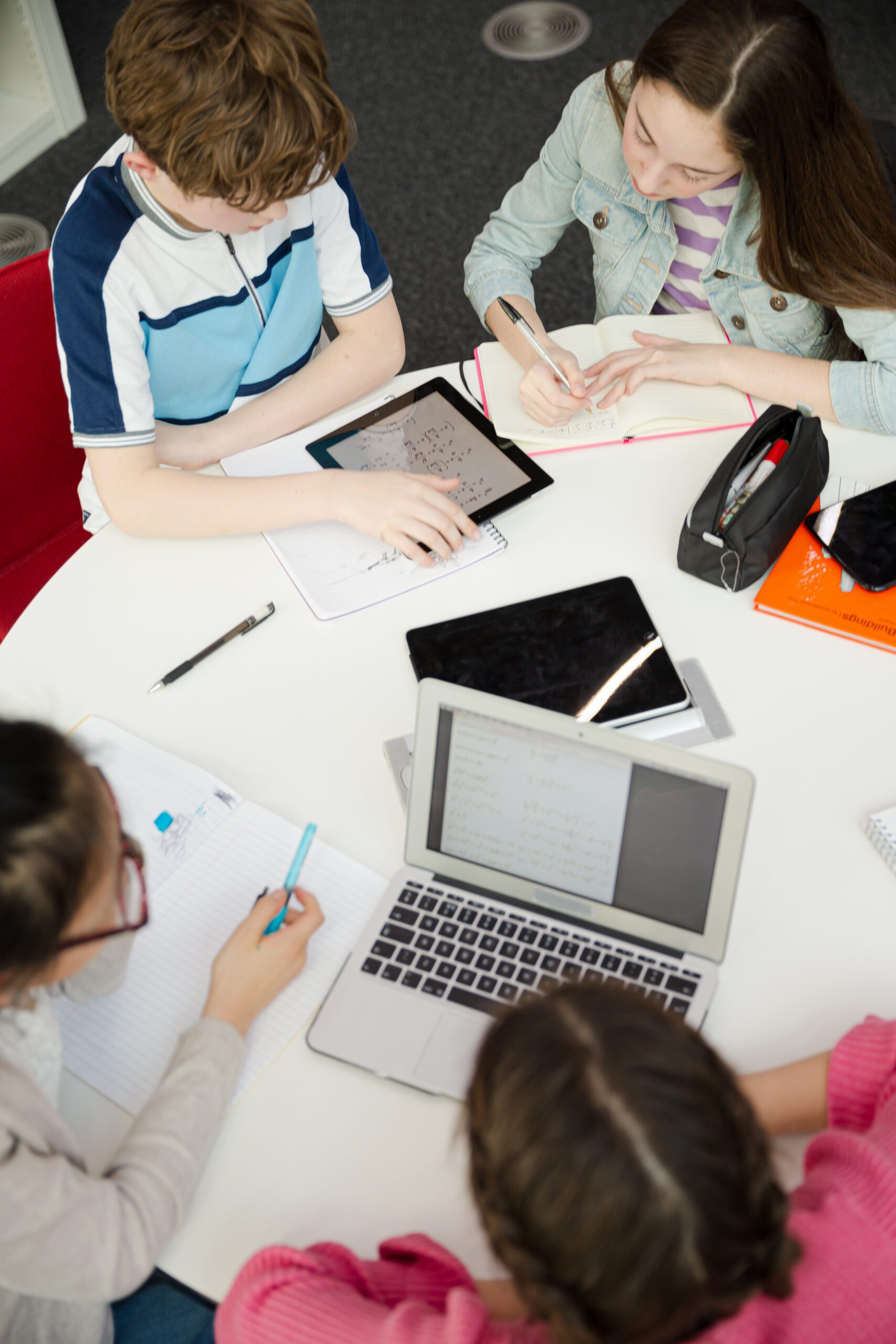students using laptops at a table.
